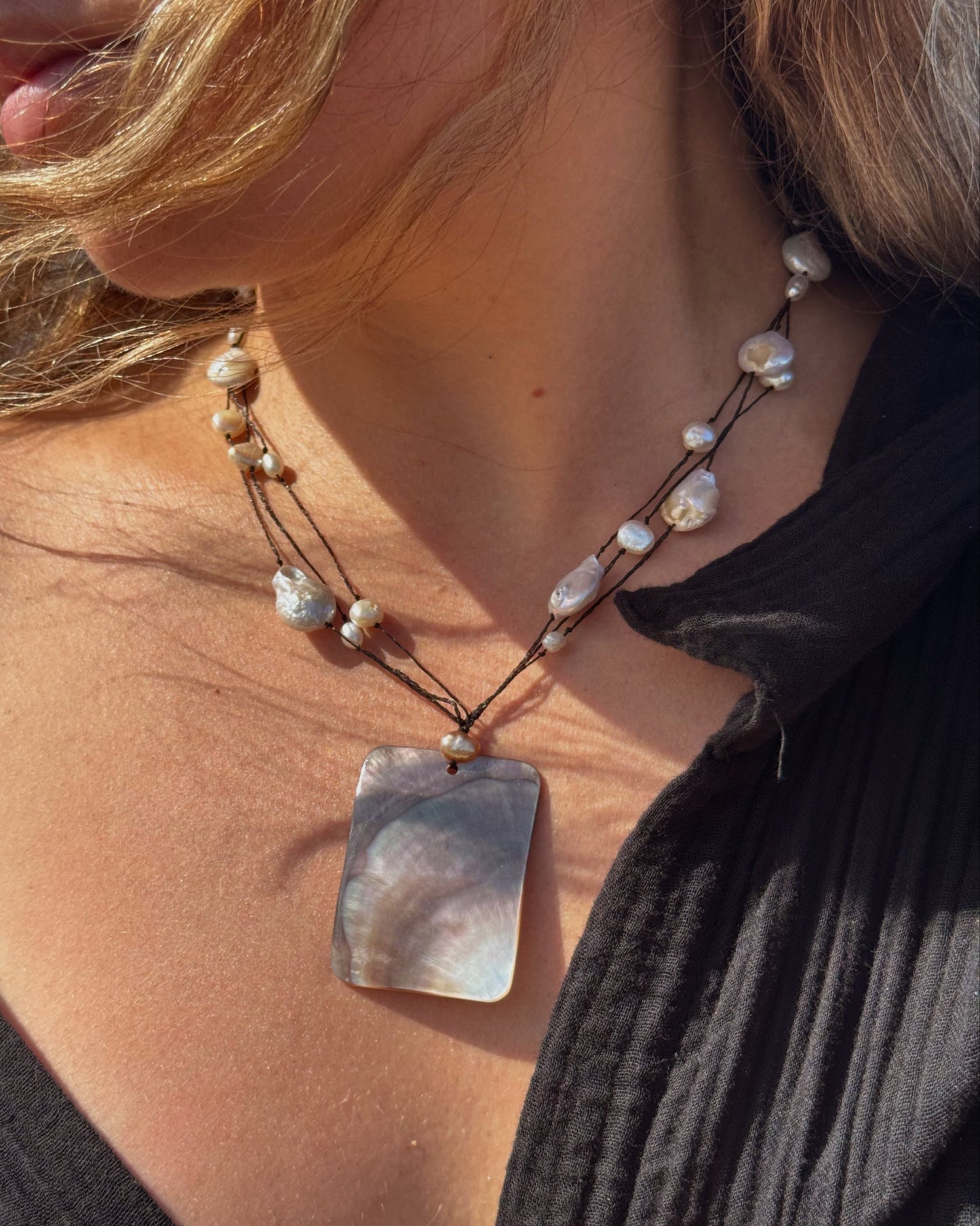 Handmade Selene Necklace with black lace wire and freshwater pearls featuring a rectangular mother of pearl pendant.