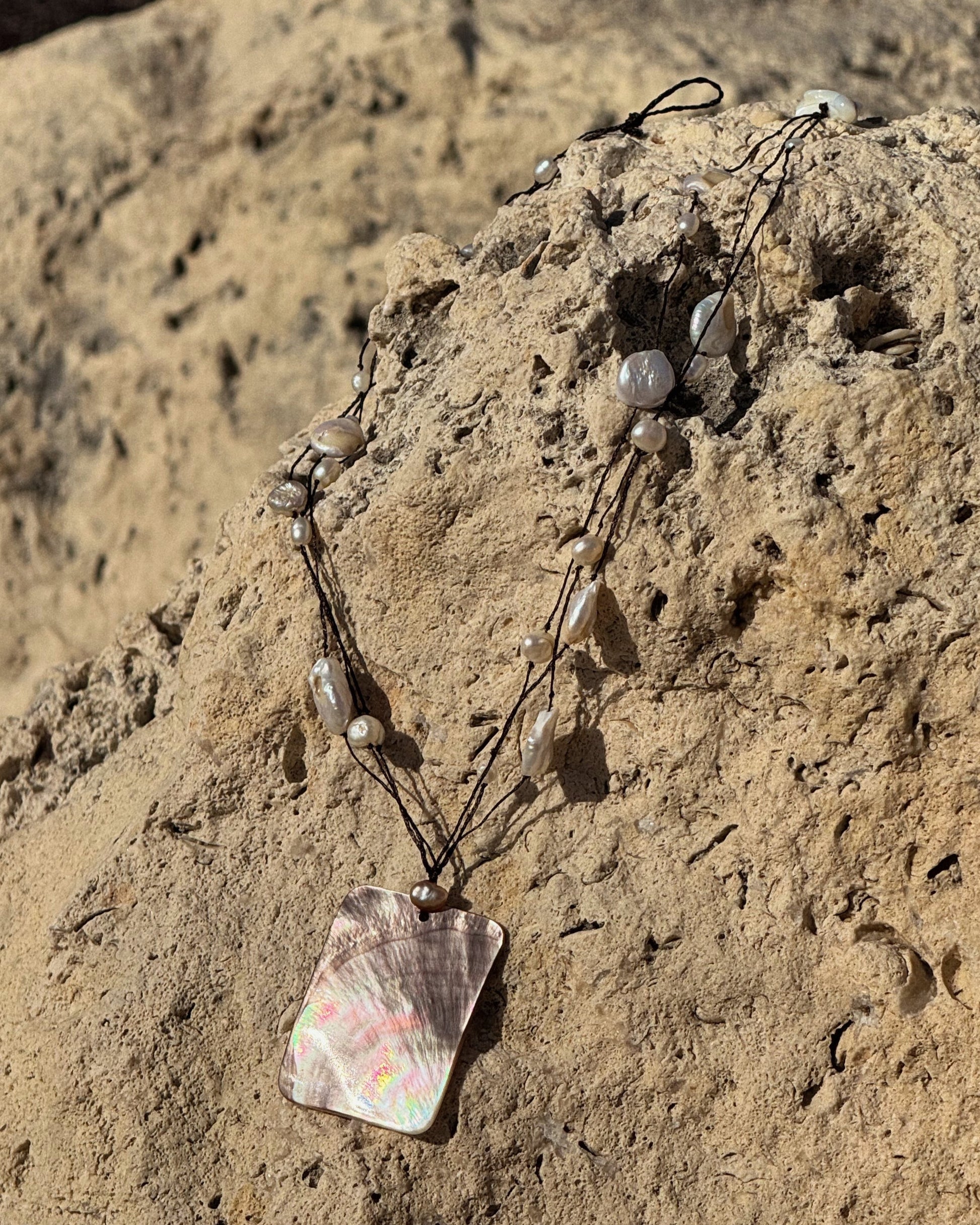 Handmade Selene Necklace with black lace wire and freshwater pearls featuring a rectangular mother of pearl pendant.
